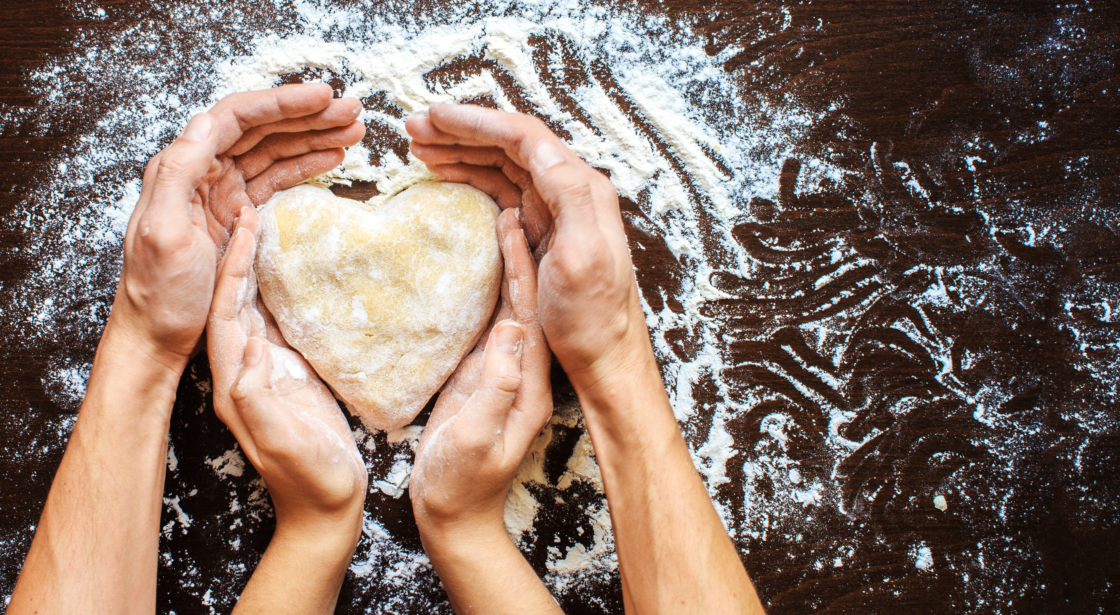 Hands holding heart-shaped dough